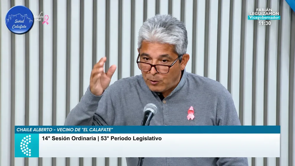 Sesión legislativa con discurso y gráficos televisivos